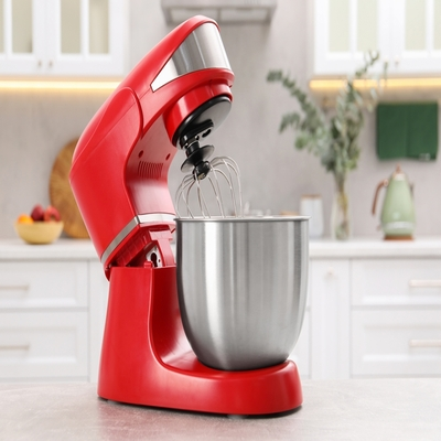 Batedeira planetária vermelha com tigela de inox sobre bancada, ideal para preparar bolos, tortas, pães e sobremesas com eficiência.