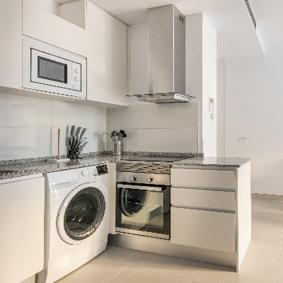 Forno multifuncional embutido em cozinha moderna com armários claros e bancada.