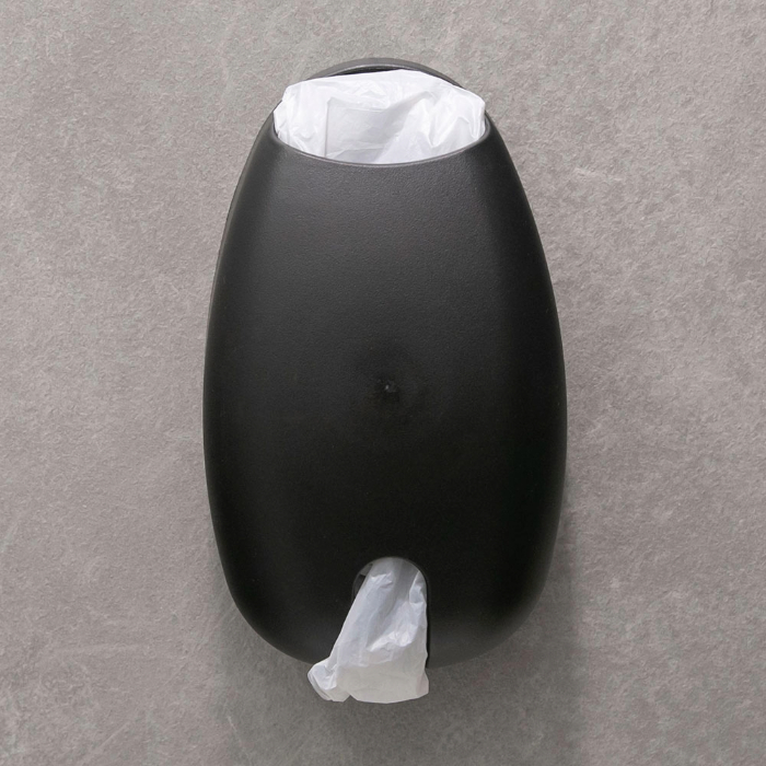 Suporte de parede preto para sacolas plásticas, com uma sacola branca visível na parte superior e outra sendo retirada pela abertura inferior.