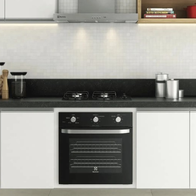 Depurador de ar em inox instalado sobre cooktop, integrado aos armários de uma cozinha moderna.