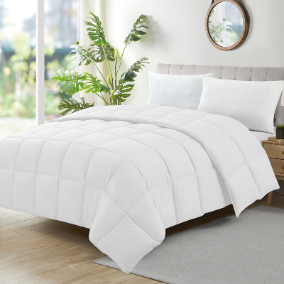 Edredom queen branco com costura em quadrados sobre cama de casal em quarto claro e moderno.