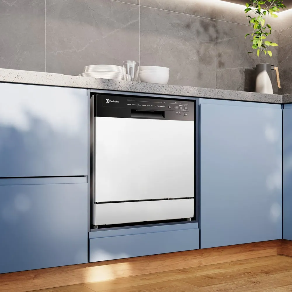 Lava-louças Electrolux de piso branca com painel de controle preto, embutida em cozinha planejada com armários azuis, bancada clara e piso de madeira.