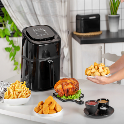 Panela elétrica em destaque sobre a bancada ao lado de alimentos prontos, perfeita para preparar refeições com rapidez e praticidade na cozinha.