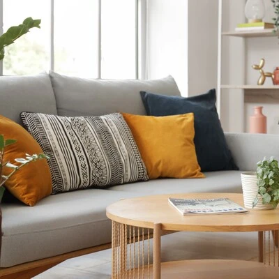 Almofadas coloridas para renovar a decoração da sala Sofá cinza decorado com almofadas em tons de laranja, amarelo, azul e estampas modernas, compondo ambiente sofisticado.