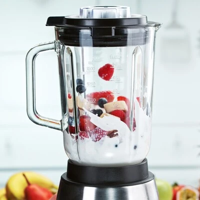 Liquidificador com frutas vermelhas e iogurte Liquidificador com copo de vidro contendo iogurte, morangos, mirtilos e banana, preparado para o preparo de vitaminas e smoothies.