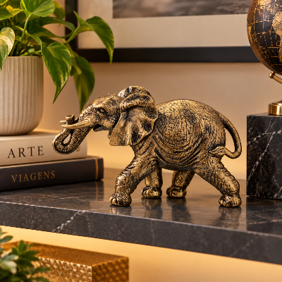 Adorno decorativo de elefante dourado sobre estante, acompanhado de livros, plantas e objetos decorativos.