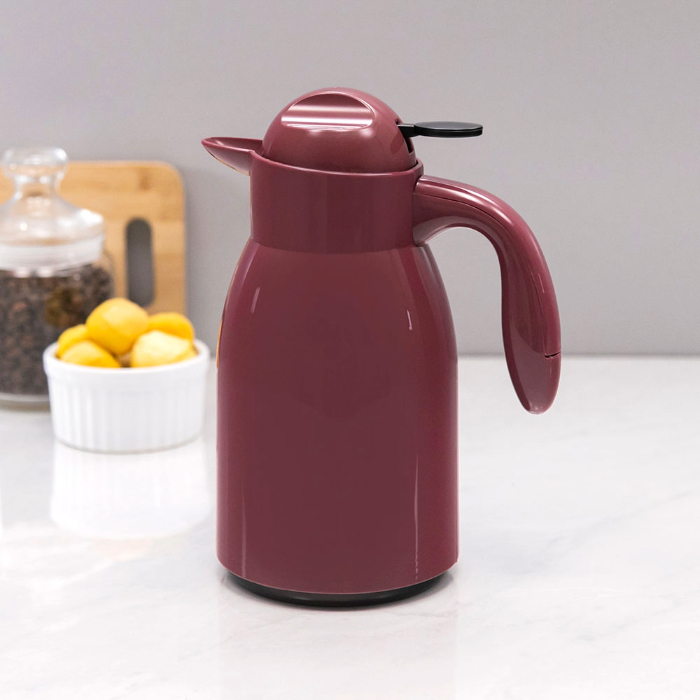 Garrafa térmica vinho com alça e tampa em uma bancada de cozinha.