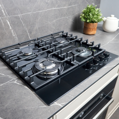 Cooktop a gás preto com cinco bocas e grades individuais, instalado em bancada de cozinha.