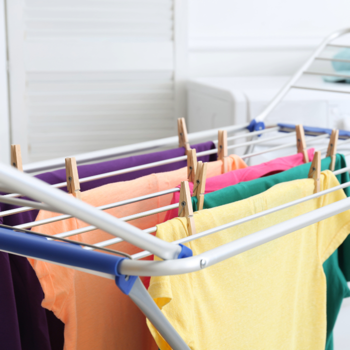 roupas coloridas estendidas em varal de chão com prendedores de madeira.