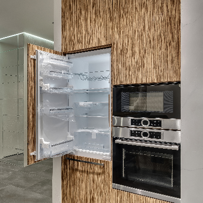 Forno multifuncional embutido em cozinha planejada com geladeira e micro-ondas.